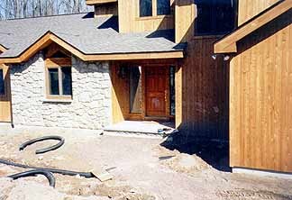 Home exterior with overgrown yard and undefined landscape areas