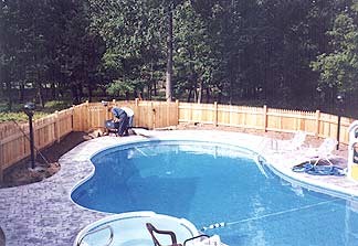 Professional landscaping surrounding a residential pool area in the Pocono Mountains, designed and installed by Living Landscapes Inc.